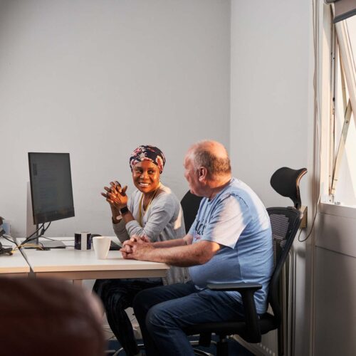 Man and woman talking infront of a computer