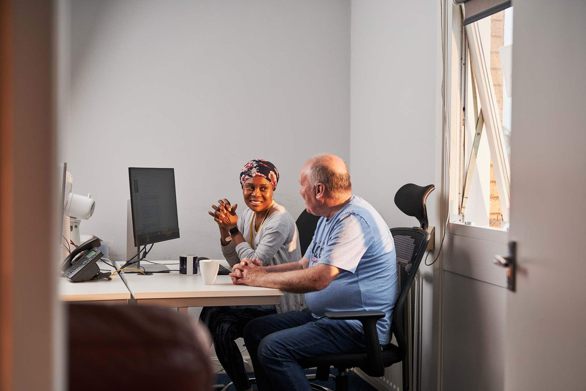 Man and woman talking infront of a computer