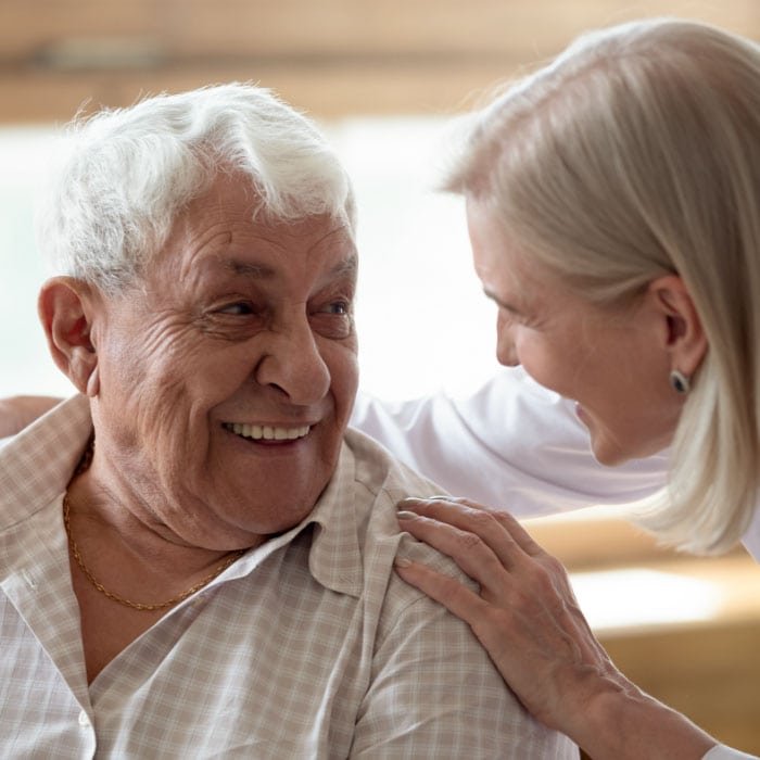 A woman and an elderly man laughing