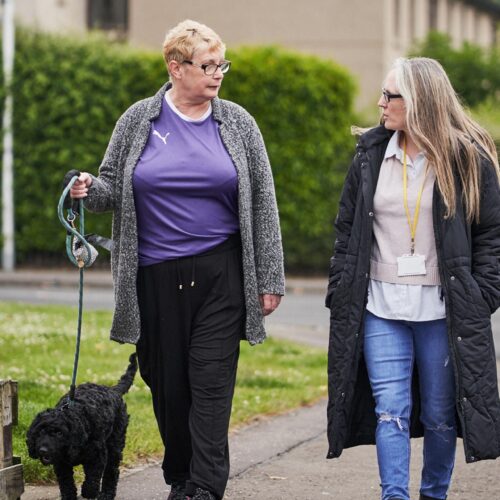 Two women walking a dog