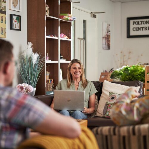 Carer sitting on couch using a laptop