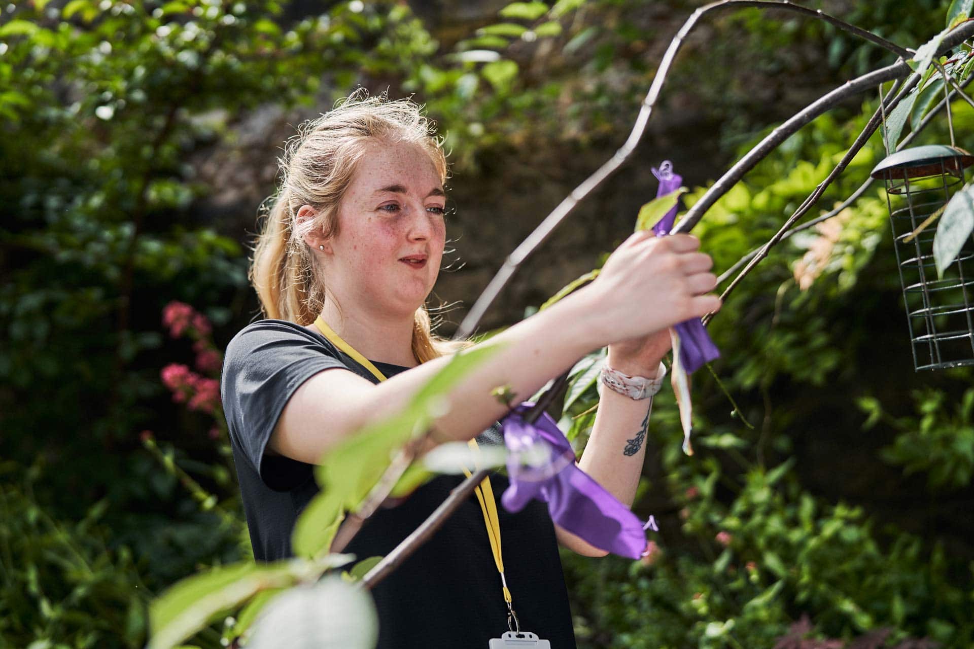 Woman tying ribbon onto a tree