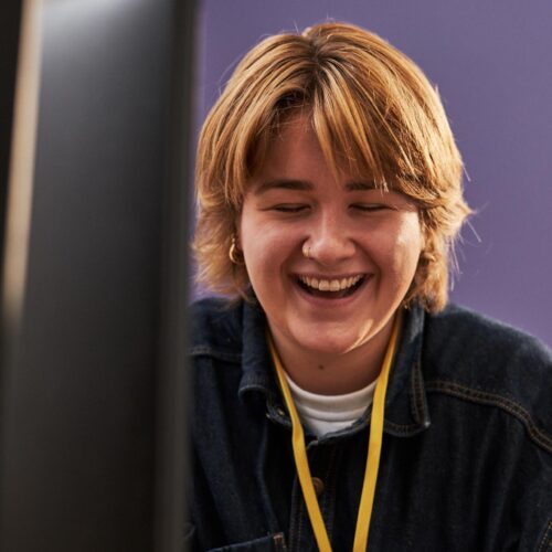 Carer smiling infront of a computer