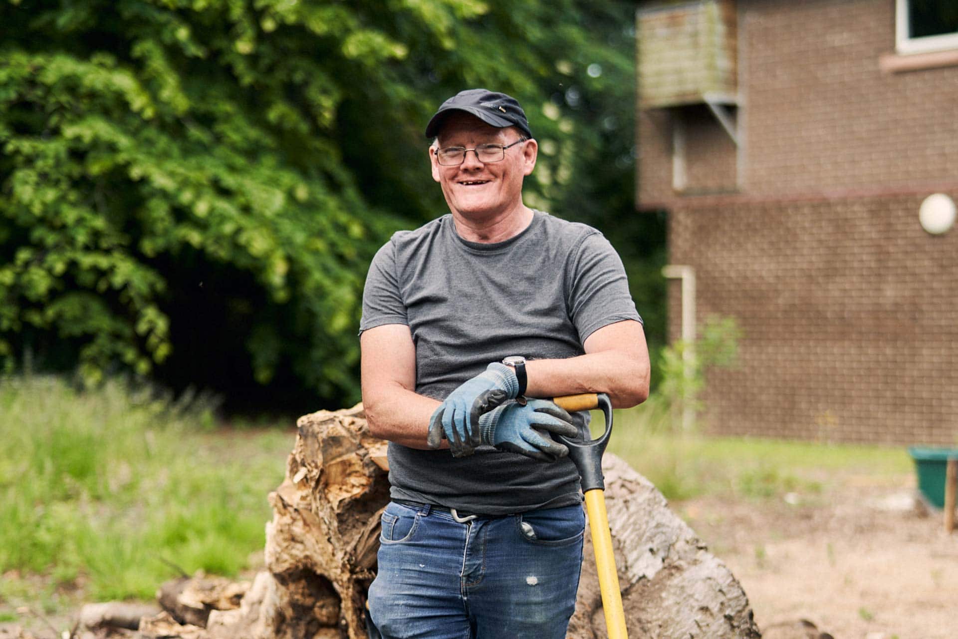 Man with shovel smiling outside