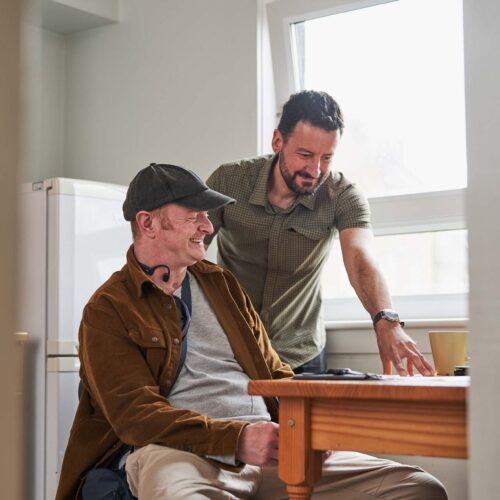 Two people working at a kitchen table