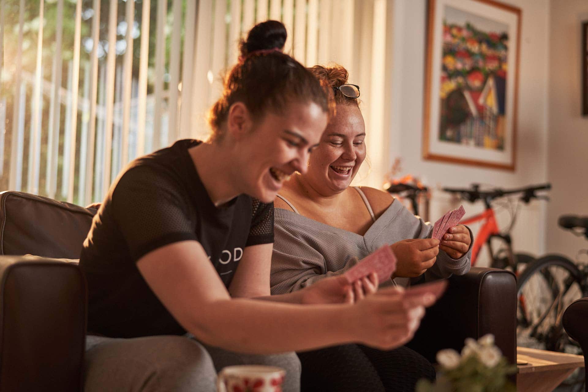 Two people smiling whilst playing cards