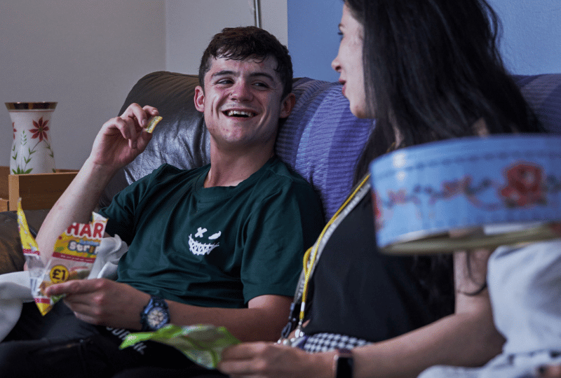 Care Support Scotland - group of young people enjoy snacks and a chat in a communual living space