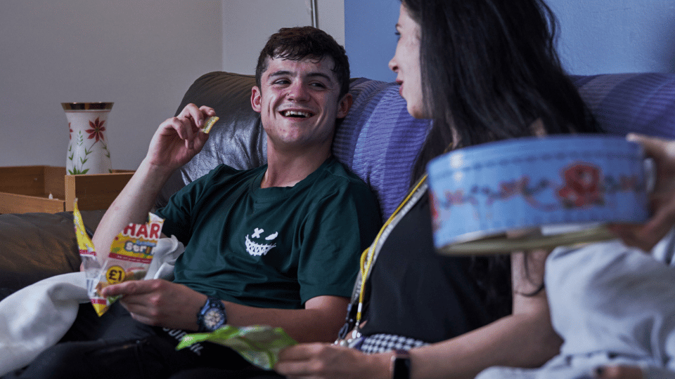 Care Support Scotland - group of young people enjoy snacks and a chat in a communual living space