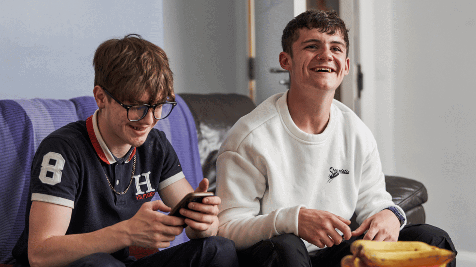 Care Support Scotland - two young residents enjoy a chat in a shared living space