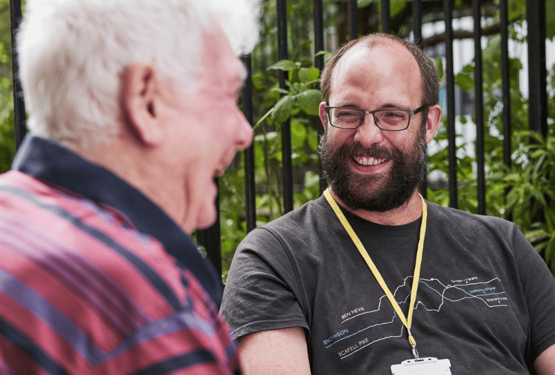 Care Support Scotland - support worker enjoys a chat with a resident in shared garden space