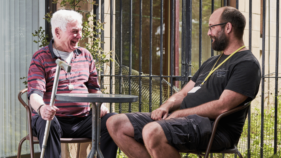 Care Support Scotland - support worker enjoys a laugh with a resident in shared garden space